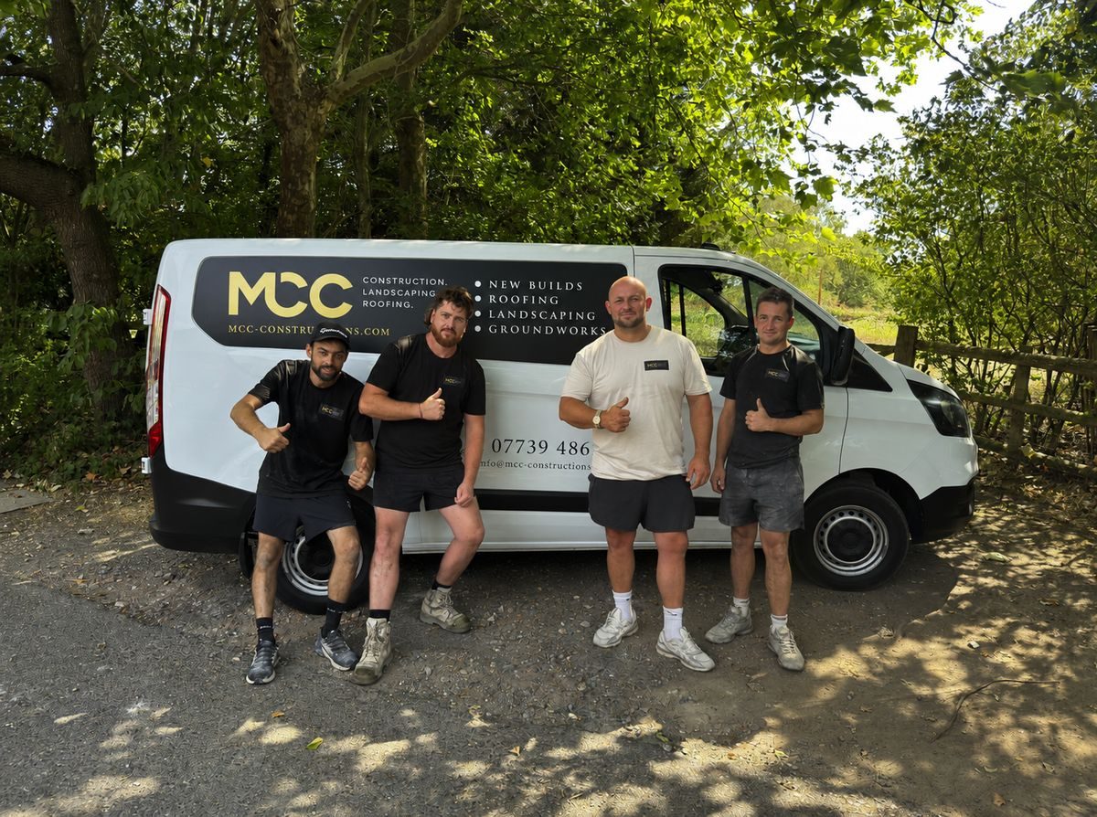 The MCC landscaping team giving a thumbs-up in front of their work van